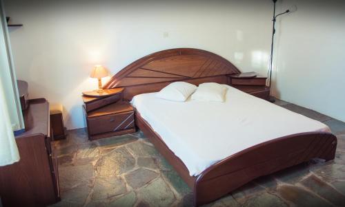 a bedroom with a large bed with a wooden headboard at Seasidehouse in Hydra