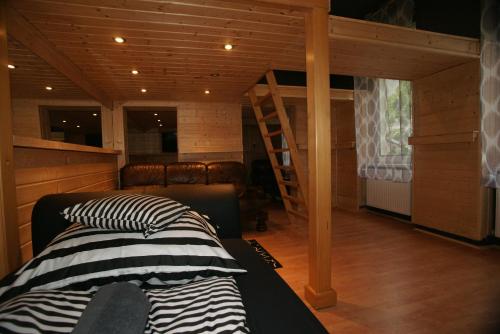 1 dormitorio con 1 cama y escaleras en una cabaña en Tattoo Apartman, en Szeged