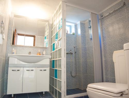 Un baño con inodoro, lavabo y ducha. en Seasidehouse, en Hydra