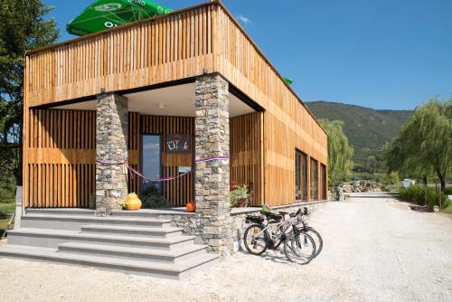 a building with two bikes parked outside of it at Mobilehouse & Camping Lijak in Šempas