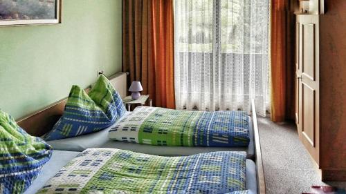 巴德小基希海姆的住宿－Appartement Ria，一间卧室配有两张带蓝色和绿色枕头的床
