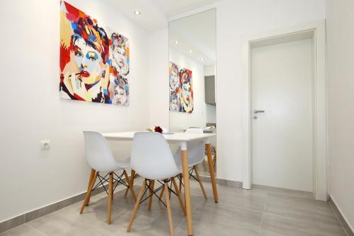 a dining room with a white table and white chairs at Apartments Maruna Self check-in in Zadar