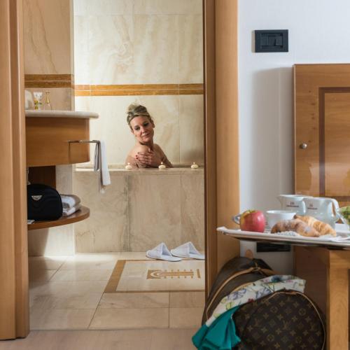 a child is taking a bath in a shower at Hotel Royal Falcone in Monza