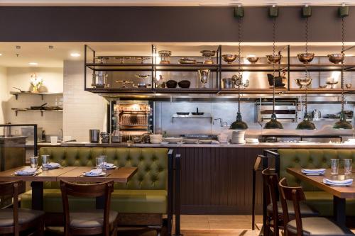 a restaurant with tables and chairs and a kitchen at Heathman Hotel in Portland