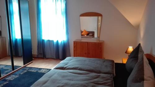 a bedroom with a bed and a mirror at FeWos im alten Bahnhof in Lauterecken