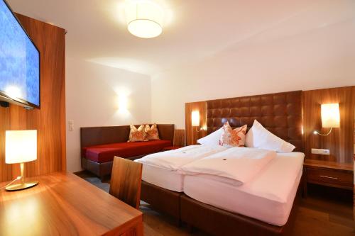 a bedroom with a large bed and a couch at Skirast - Kirchberg in Kirchberg in Tirol