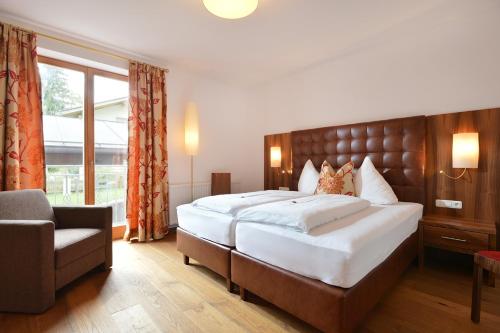a hotel room with a large bed and a chair at Skirast - Kirchberg in Kirchberg in Tirol