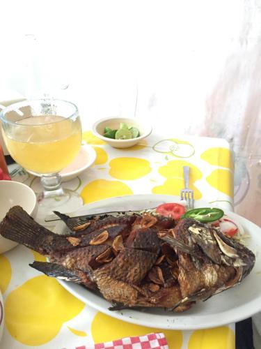 a plate of fish on a table with a glass of juice at Casa Q BnB in Mexico City
