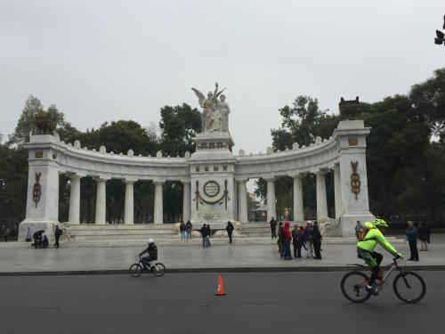 a group of people riding bikes in front of a monument at Casa Q BnB in Mexico City