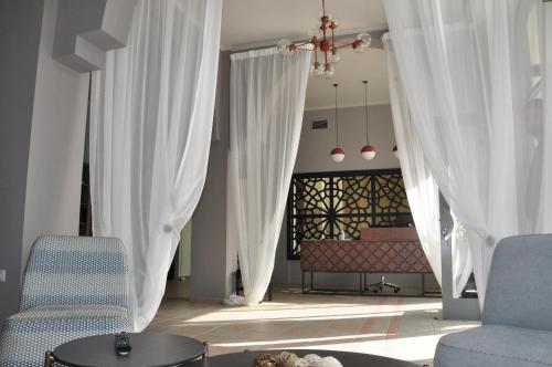 Artemis في تولو: غرفة معيشة مع ستائر بيضاء وأريكة