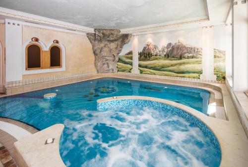 ein Pool in einem Haus mit einem Gemälde an der Wand in der Unterkunft Hotel Seelaus in Alpe di Siusi