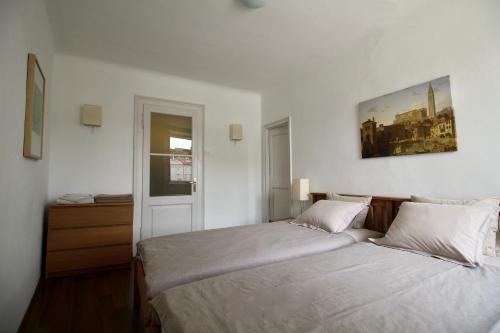 a bedroom with two beds and a picture on the wall at Apartment Marciana in Piran
