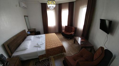 a bedroom with a bed and a desk and chairs at Villa Royal House in Makhinjauri