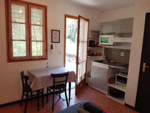 une cuisine avec une table et des chaises dans une pièce dans l'établissement A CASA DI L'ALIVU, à Patrimonio