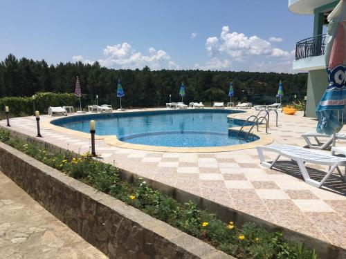 a swimming pool in a resort with chairs and tables at Dream Bay Apartments in Tsarevo