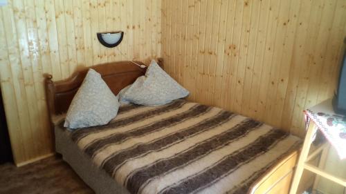 un letto con due cuscini sopra in una stanza di Villa Doina a Voronet