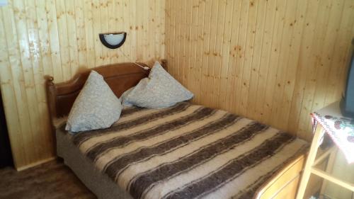 a bed with two pillows on it in a room at Villa Doina in Voronet