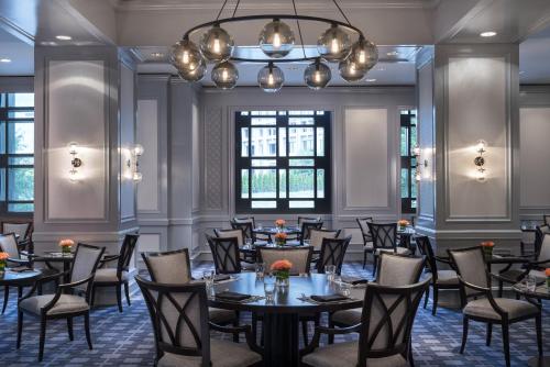 a dining room with tables and chairs and a chandelier at Four Seasons Hotel Atlanta in Atlanta