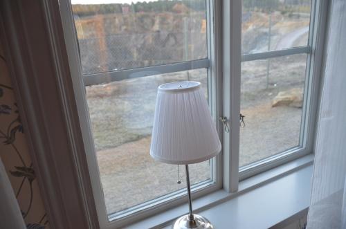 a white lamp sitting in front of a window at Polhem Bed & Breakfast in Falun