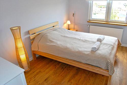 a bedroom with a bed with a wooden floor and a window at HelApart - Bałtyk in Hel