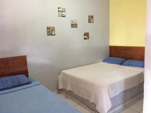 a room with two beds and pictures on the wall at Pousada Recanto das Pedras São Leopoldo in Pirenópolis