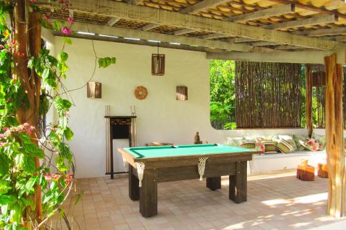 a patio with a pool table in a yard at Pousada Villages Boutique Hotel - 150m da Praia da Laje in Pôrto de Pedras