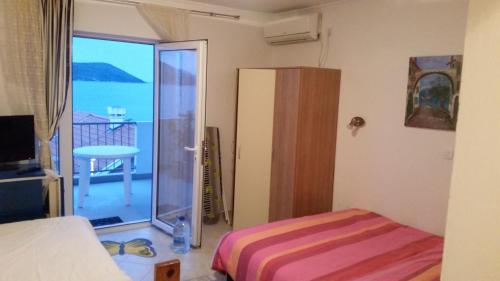 a bedroom with a bed and a sliding glass door at Apartments Miljevic in Herceg-Novi