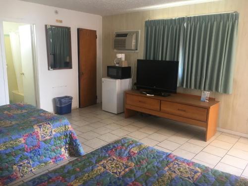 Habitación de hotel con 2 camas y TV de pantalla plana. en Skylark Resort Motel, en Wildwood