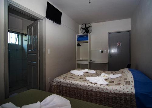 a small bedroom with two beds and a shower at Pousada Araxá in Araxá