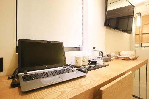 a laptop computer sitting on top of a wooden desk at Delight Hotel Jamsil in Seoul