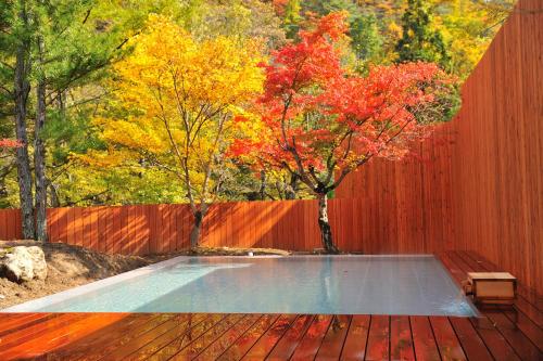a swimming pool on a wooden deck next to a fence at Yukaen in Hanamaki
