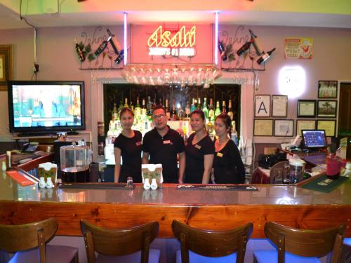 a group of people standing at a bar at West Plaza Malakal in Koror