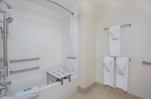 baño blanco con ducha y lavamanos en Holiday Inn Express & Suites Covington, an IHG Hotel en Covington