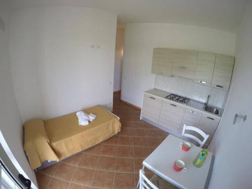 a small room with a bed and a kitchen at Residence Pantaleo in Ricadi