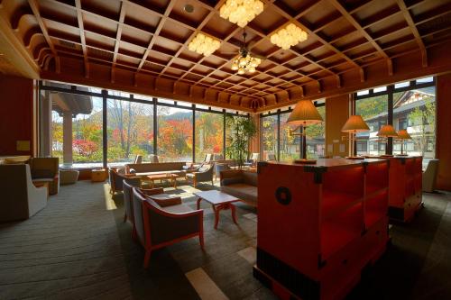 a living room with tables and chairs and windows at Yukaen in Hanamaki