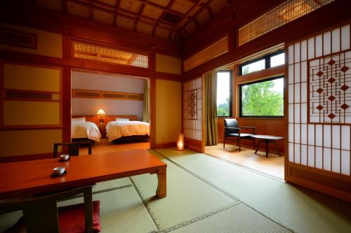a room with a bedroom with a bed and a desk at Yukaen in Hanamaki
