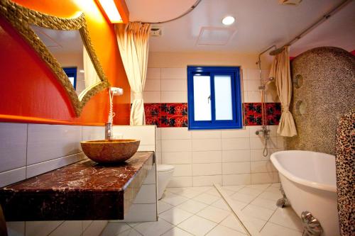 墾丁的住宿－金海旅店，浴室配有盥洗盆、浴缸和盥洗盆