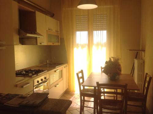 una cucina con tavolo e sedie e una cucina con finestra di Villa Giulia a Rimini