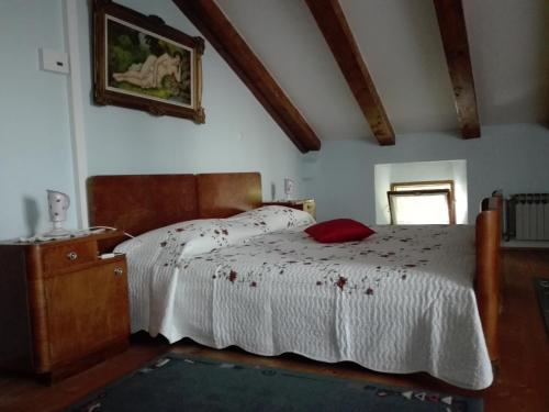 a bedroom with a bed with a red pillow on it at Apartments Lazzarini Battiala in Nedeščina