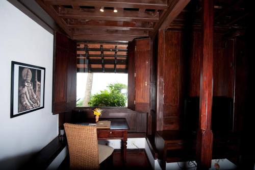 a dining room with a table and a window at Niraamaya Wellness Retreats, Surya Samudra, Kovalam in Kovalam