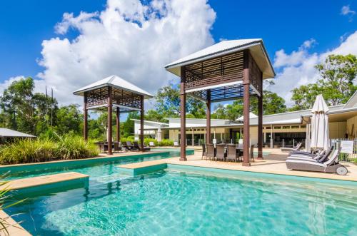 an image of a swimming pool with a gazebo at Beach Road Holiday Homes in Noosa North Shore