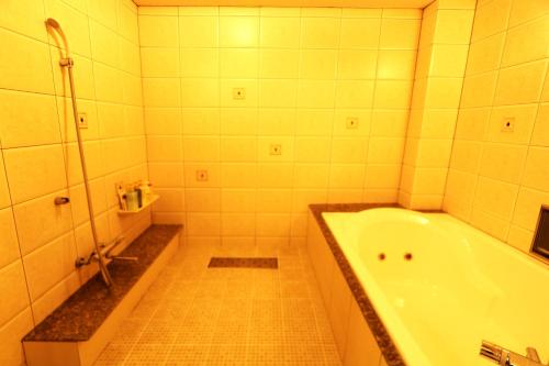 a bathroom with a bath tub and a shower at AURA Resort Nara (Adult Only) in Nara