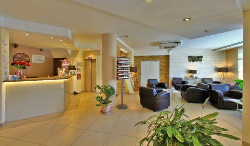 a lobby with couches and chairs in a hospital at The Originals City, Hôtel de Bordeaux, Bergerac centre in Bergerac