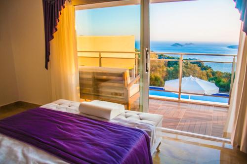 1 dormitorio con 1 cama y balcón con vistas. en Villa Erdo Kalkan 5 Bedroom Villa en Kalkan