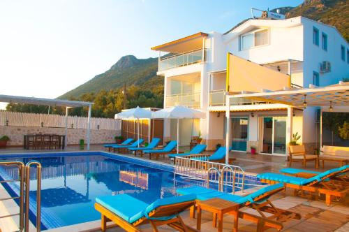 ein Hotel mit einem Swimmingpool mit Stühlen und einem Gebäude in der Unterkunft Villa Erdo Kalkan 5 Bedroom Villa in Kalkan