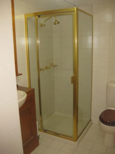 a bathroom with a glass shower with a toilet at Fairthorpe Apartments in Brisbane