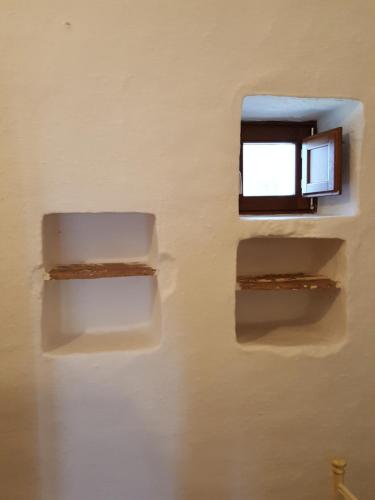 two shelves on a wall with a window at Masseria Trulli sull'Aia in Cisternino