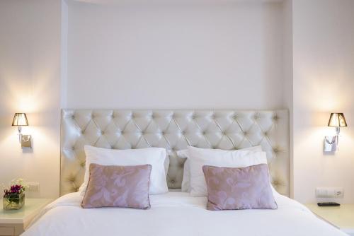 a bedroom with a white bed with two pillows at Calma Hotel & Spa in Kastoria