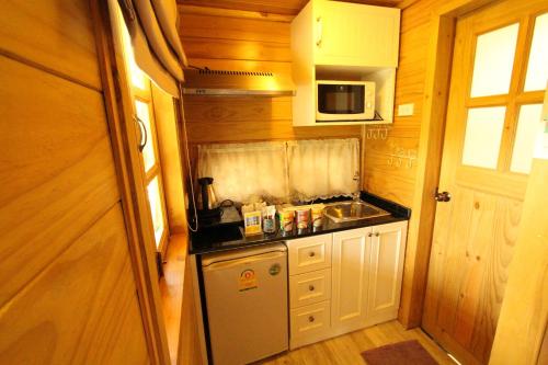 a small kitchen with a sink and a microwave at At Residence Suvarnabhumi Hotel in Lat Krabang