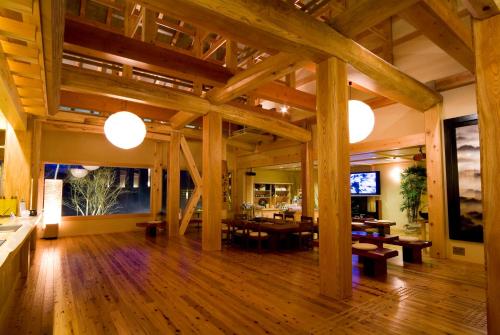 a large room with wooden floors and wooden beams at Miyama Ouan Kyoritsu Resort in Takayama
